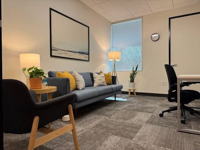Emily Ward's counseling office, with a couch, soft lamps, and plants